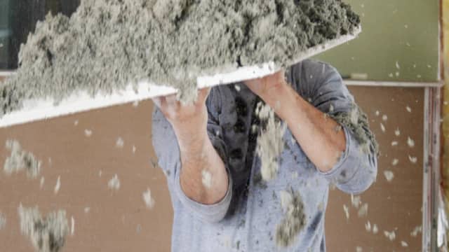 Loose-fill cellulose insulation being removed during a tear-out